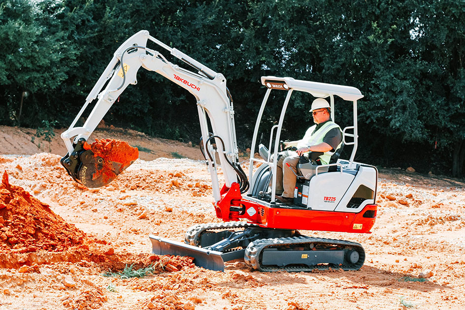 Mini-pelle Takeuchi TB225 déplaçant des matériaux sur chantier